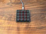 A Keebio Chocopad 4x4 keyboard with blank keycaps and red backlighting.